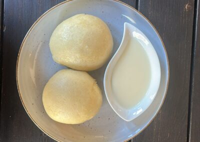 Teller mit Dampfnudeln und Vanillesoße.